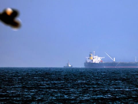 Tug boats are moored next to Israeli-linked tanker MT Mercer Street which was attacked on August 3, 2021.