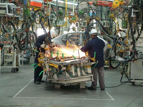 Workers at an auto manufacturing plant. Supported by policies on investment, infrastructure and labour reforms, the environment for fostering industrial growth has increased greatly