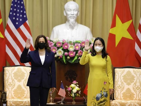 US Vice President Kamala Harris (L) waves beside Vietnam's Vice President Vo Thi Anh Xuan in the Gold room of the Presidential Palace in Hanoi on August 25, 2021.