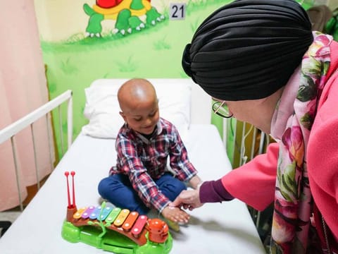 Her Highness Sheikha Jawaher bint Mohammed Al Qasimi interacts with a young patient