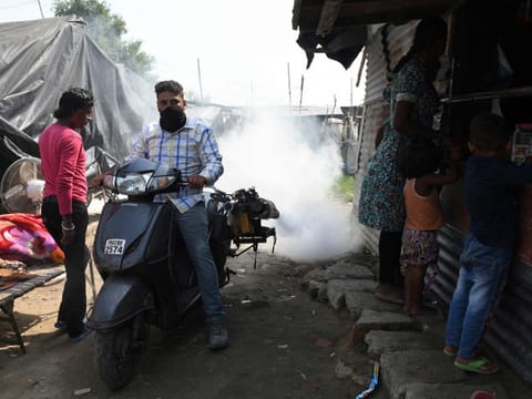 A worker of the Municipal Corporation Amritsar (MCA) sprays mosquito repellent as part of a prevention campaign against dengue fever in a slum area in Amritsar on October 10, 2021.