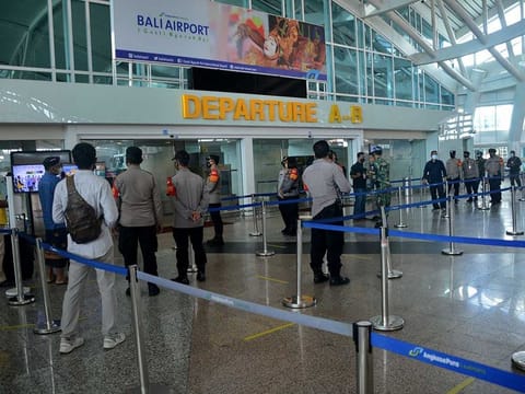 Airport officers stand in the international departure terminal at Ngurah Rai airport in Tuban on Indonesia's resort island of Bali