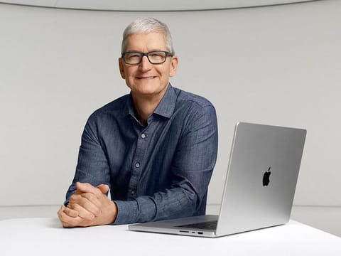 Apple CEO Tim Cook poses with a new MacBook Pro during an online event unveiling new products at Apple Park in Cupertino, California.