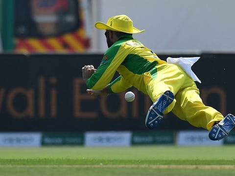Australia's Glenn Maxwell dives to stop the ball during the ICC T20 World Cup cricket match against South Africa at the Sheikh Zayed Cricket Stadium in Abu Dhabi