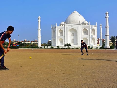 In this photograph taken on November 25, boys play cricket in front of a replica of the Taj Mahal at Burhanpur in India's Madhya Pradesh state.
