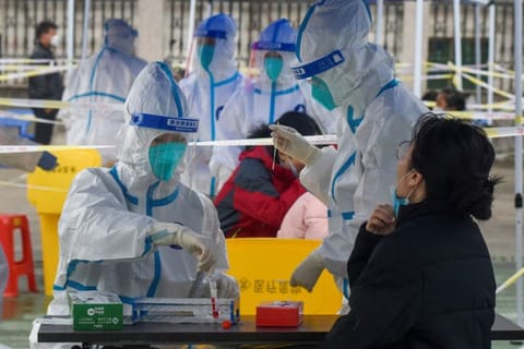 Medical workers collect swabs from residents during a third round of mass testing for COVID-19 in Zhenhai district of Ningbo, Zhejiang province, China December 12, 2021.