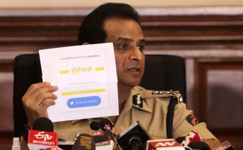 Mumbai police commissioner Hemant Nagrale displays a document as he addresses a press conference in Mumbai, on January 5, 2022.
