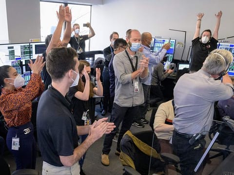 In this photo released by NASA, the James Webb Space Telescope mission operations team celebrates on January 8, 2022, at the Space Telescope Science Institute in Baltimore, Maryland, after confirming that the observatory’s final primary mirror wing successfully extended and locked into place.