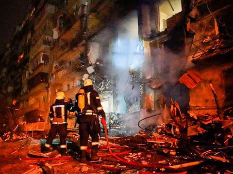 Firefighters inspect the damage at a building following a rocket attack on the city of Kyiv, Ukraine. File hoto taken on February 25, 2022.