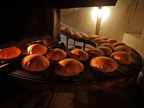 Freshly-baked bread moves along a production line out of an oven at an automated bakery in Lebanon's capital Beirut. Lebanon’s current stock, in addition to five ships from Ukraine waiting to be offloaded, “can only last for one month and a half”, said Ahmad Hoteit, the representative of Lebanon’s wheat importers.