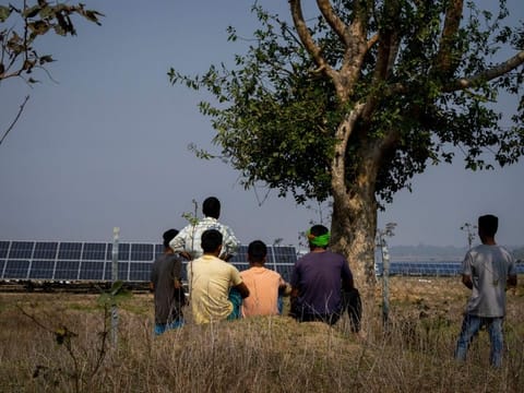 Farmers who’s agriculture lands occupied look at the solar power plant in Mikir Bamuni village in Nagaon district east of Gauhati, India.