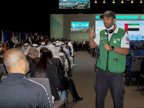 Yehia Saleh Al Ammari, a sign language interpreter from Dubai Police, assists a visitor at World Government Summit in Expo 2020 Dubai.