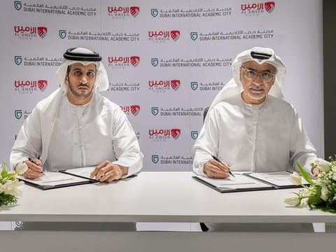 Omar Al Felasi (L) from Al Ameen Service and Mohammed Abdullah from DIAC signing the agreement