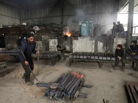 Workers labour at a metal factory in the industrial zone of Syria's rebel-held city of Al Bab.