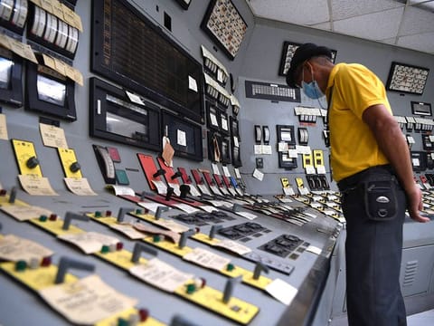 An employee checking switches inside the control room at the Bataan Nuclear Power Plant.