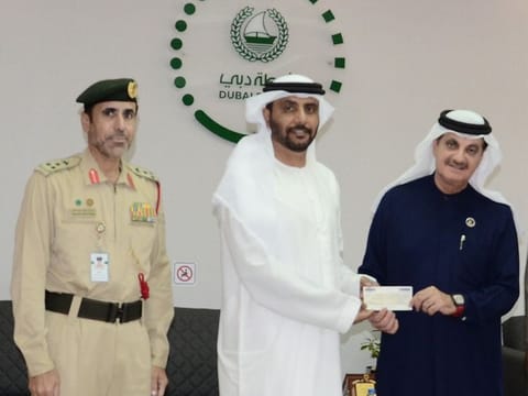 Yaqoob Al Ali (right) handing over the donation to Major General Dr Mohammad Al Murr (middle)