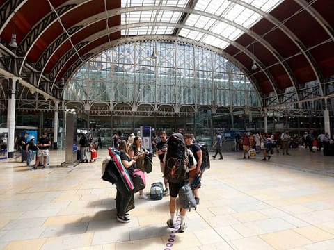 Travellers with camping equipment wait at Paddington Station in London the day after national rail strike