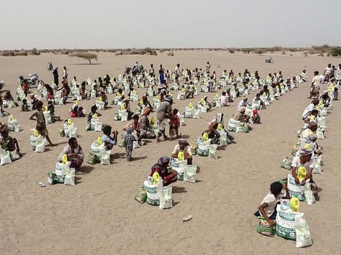 Yemenis displaced by the conflict, receive food aid and supplies to meet their basic needs, at a camp in Hays district in the war-ravaged western province of Hodeida, on July 6, 2022.