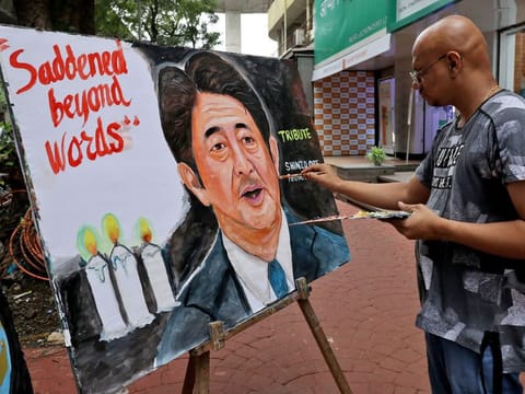 An artist applies finishing touches to a painting of Japan’s former prime minister Shinzo Abe, who died hours after he was shot while campaigning for a parliamentary election in Japanese western city of Nara, as part of a tribute to him outside an art school in Mumbai, India, July 8, 2022.