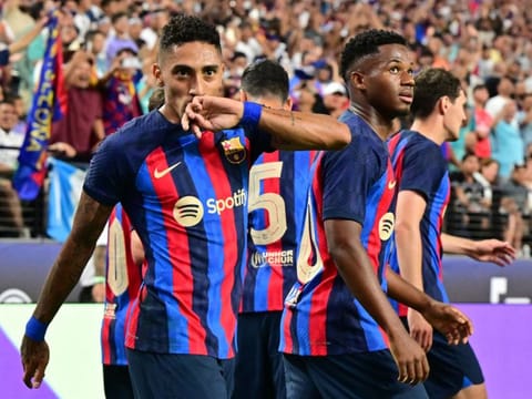 Barcelona's Raphinha celebrates with teammates after scoring during the friendly match against Real Madrid at Allegiant Stadium in Las Vegas, Nevada.