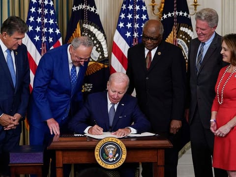 President Joe Biden signs the landmark bill in the State Dining Room of the White House
