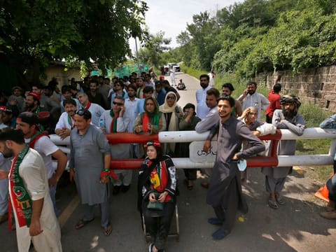 Supporters of Pakistan's former Prime Minister Imran Khan's party gather outside his residence in Islamabad, on August 22, 2022.