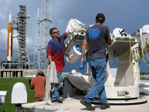 Nasa workers prepare a tracking camera near new moon rocket as she sits on Launch Pad 39-B.