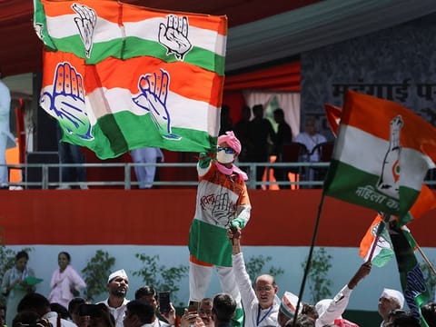 A supporter waves a flag of India's main opposition Congress party at a large Congress rally in New Delhi, India.