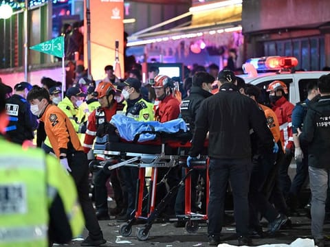 A person, believed to have suffered from cardiac arrest, is transported on a stretcher in the popular nightlife district of Itaewon in Seoul.