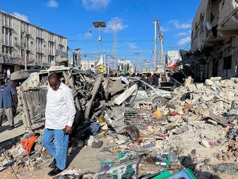 A man walks past wreckage of destroyed vehicles near the ruins of a building at the scene of an explosion along K5 street in Mogadishu, Somalia October 30, 2022. Al Shabab, an Al Qaida-affiliate that for well over a decade has carried out high-profile bombings in Somalia’s capital and controlled parts of the country’s central and southern regions.