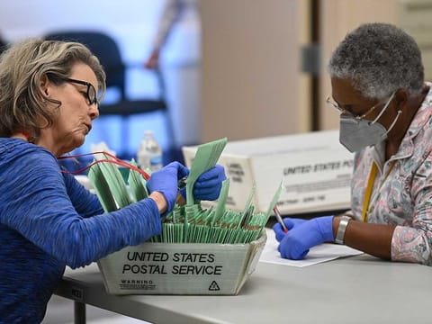 In Maricopa County, by far Arizona's most populous county and home to Phoenix, it was reported on Thursday that counting a backlog of more than 400,000 votes would likely take until next week. Photo shows Maricopa County election workers.