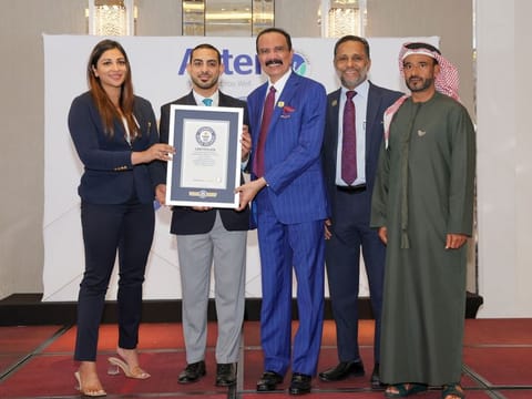 Alwaleed Osman (second from left) hands over the Guinness Record certificate to Dr. Azad Moopen (third from left) and Alisha Moopen (first from left). They were joined by Shamsudheen Bin Mohideen (extreme right) and T J Wilson.