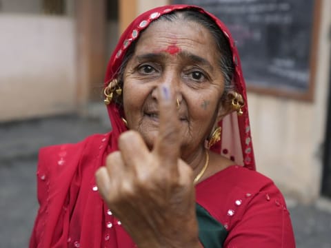 A woman shows her inked finger after casting her vote during the first phase of Gujarat state legislature elections in Limbadi, India, Thursday, Dec. 1, 2022.