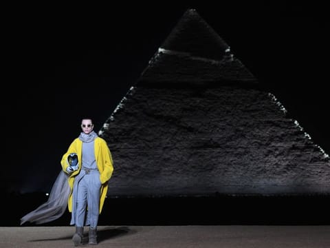 A model presents a creation at the Christian Dior fashion show at the Giza Pyramids Necropolis on the outskirts of the twin city of Egypt's capital on December 3, 2022. - French fashion house Dior today held its first show at Egypt's ancient Giza pyramids, presenting its 2023 fall men's collection in the shadow of the of the millennia-old tombs. (Photo by Ahmed HASAN / AFP)