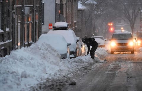 A man shovels his car out of a street parking space, as a major storm hits eastern Canada on Friday, Dec. 23, 2022 in Quebec City. (Jacques Boissinot/The Canadian Press via AP)