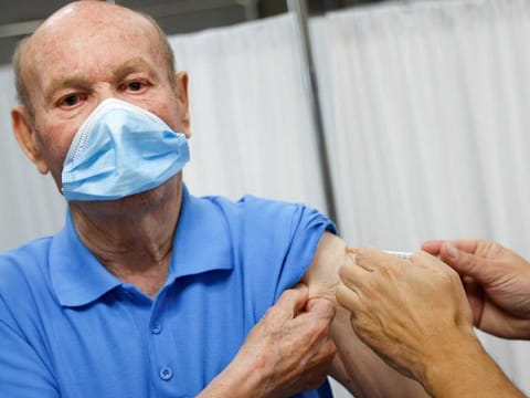 An elderly man receives a coronavirus disease (COVID-19) vaccine booster coinciding with the flu vaccination campaign in Seville, Spain October 18, 2021.