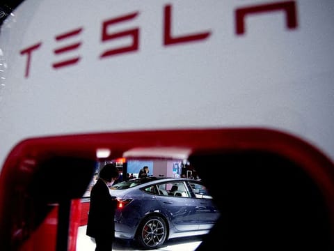 A Tesla electric vehicle is seen through a charging point displayed during a media day for the Auto Shanghai show in Shanghai, China.