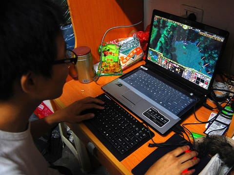 A college student plays the online game World of Warcraft in his dormitory room in southwest China's Chongqing city on Oct. 12, 2009.