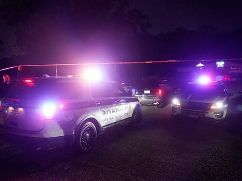Law enforcement personnel control the scene of a shooting in Half Moon Bay, California.