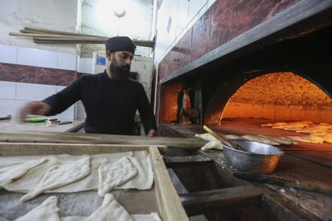 A staff member mans the oven at a bakery for Samoon bread in Al Rashid street, in Iraq's capital Baghdad.