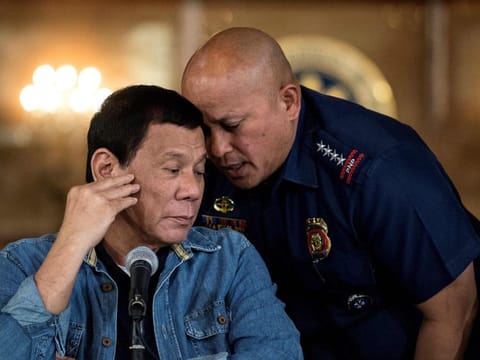 This file photo taken on January 30, 2017 shows then-Philippine President Rodrigo Duterte talking to Philippine National Police director general Ronald Dela Rosa during a press conference at the Malacanang palace in Manila.