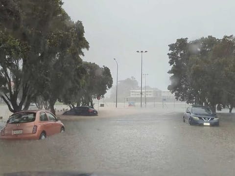 Cars are seen in a flooded street during heavy rainfall in Auckland, New Zealand January 27, 2023, in this screen grab obtained from a social media video.