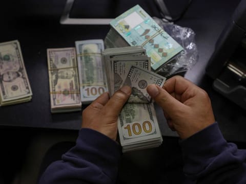 A money exchange vendor counts US dollar banknotes at his shop in Beirut. The currency has lost more than 95 per cent of its market value to the dollar since 2019, and more than 80 per cent of the population lives in poverty, according to the United Nations.