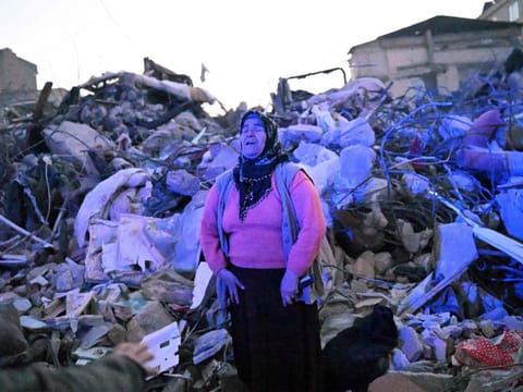 A woman cries as she stands in the rubble hoping her relatives to be found by rescuers in Hatay as rescue teams began to wind down the search for survivors.