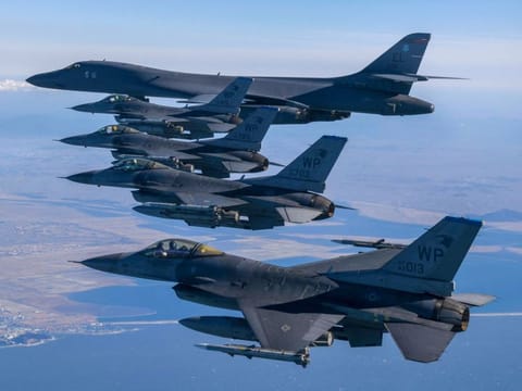 This handout photo taken and provided on February 19, 2023 by the South Korean Defence Ministry in Seoul shows a US Air Force B-1B bomber (top) and US Air Force F-16 fighter jets flying over the South Korea Peninsula during a joint air drill in South Korea.