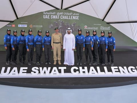 Sheikh Hamadan bin Mohammed and Lieutenant General Abdullah Khalifa Al Marri standing for photo with the Dubai Police all women Swat team
