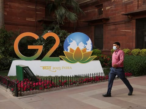 A man walks past a model of G20 logo outside the finance ministry in New Delhi, India, March 1, 2023.