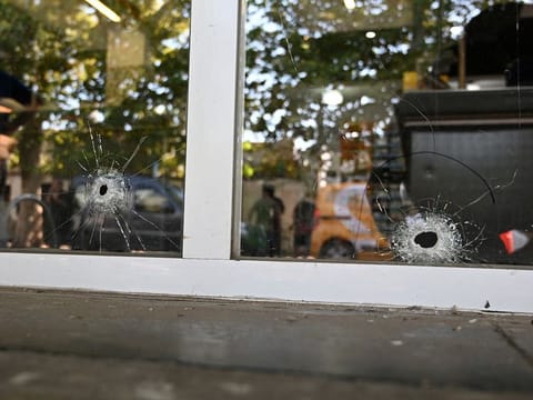 Bullet holes are pictured on a supermarket door that belongs to the family of Antonela Roccuzzo, wife of Lionel Messi, after two people on motorcycles attacked it and left a threatening message for Messi and the city mayor, Pablo Javkin, in Rosario, Santa Fe province, Argentina March 2, 2023.