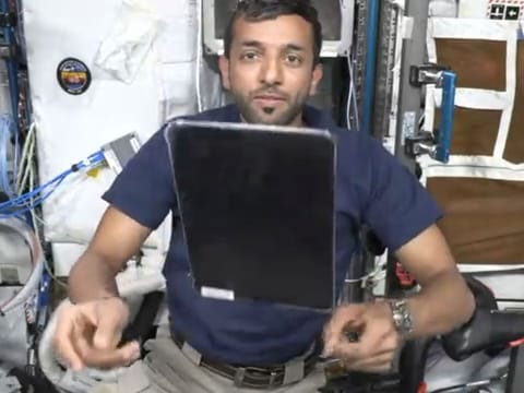 Still from video showing Al Neyadi flipping an iPad on ISS