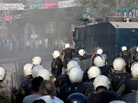 Riot police use water cannon to push back supporters of former prime minister Imran Khan gathered outside Khan's house to prevent officers from arresting him, in Lahore on March 14, 2023.